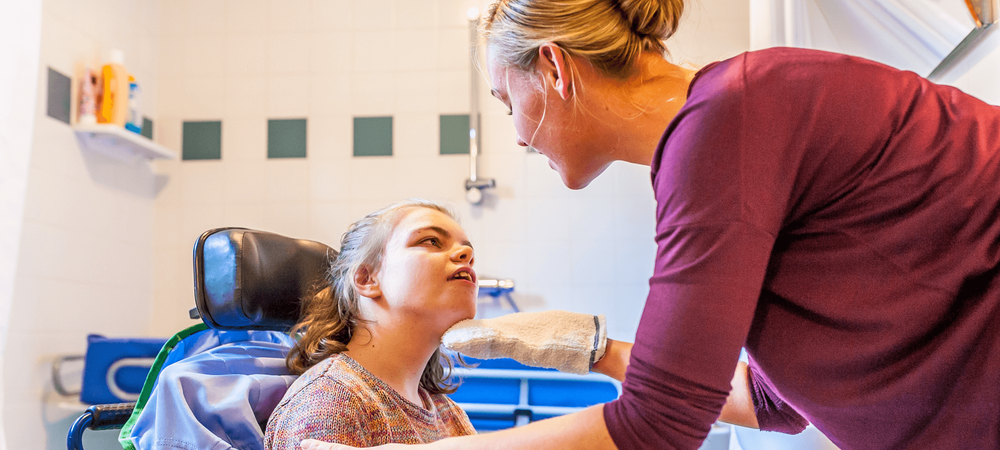 A therapist and a young girl with a developmental disability smile at each other in an exam room