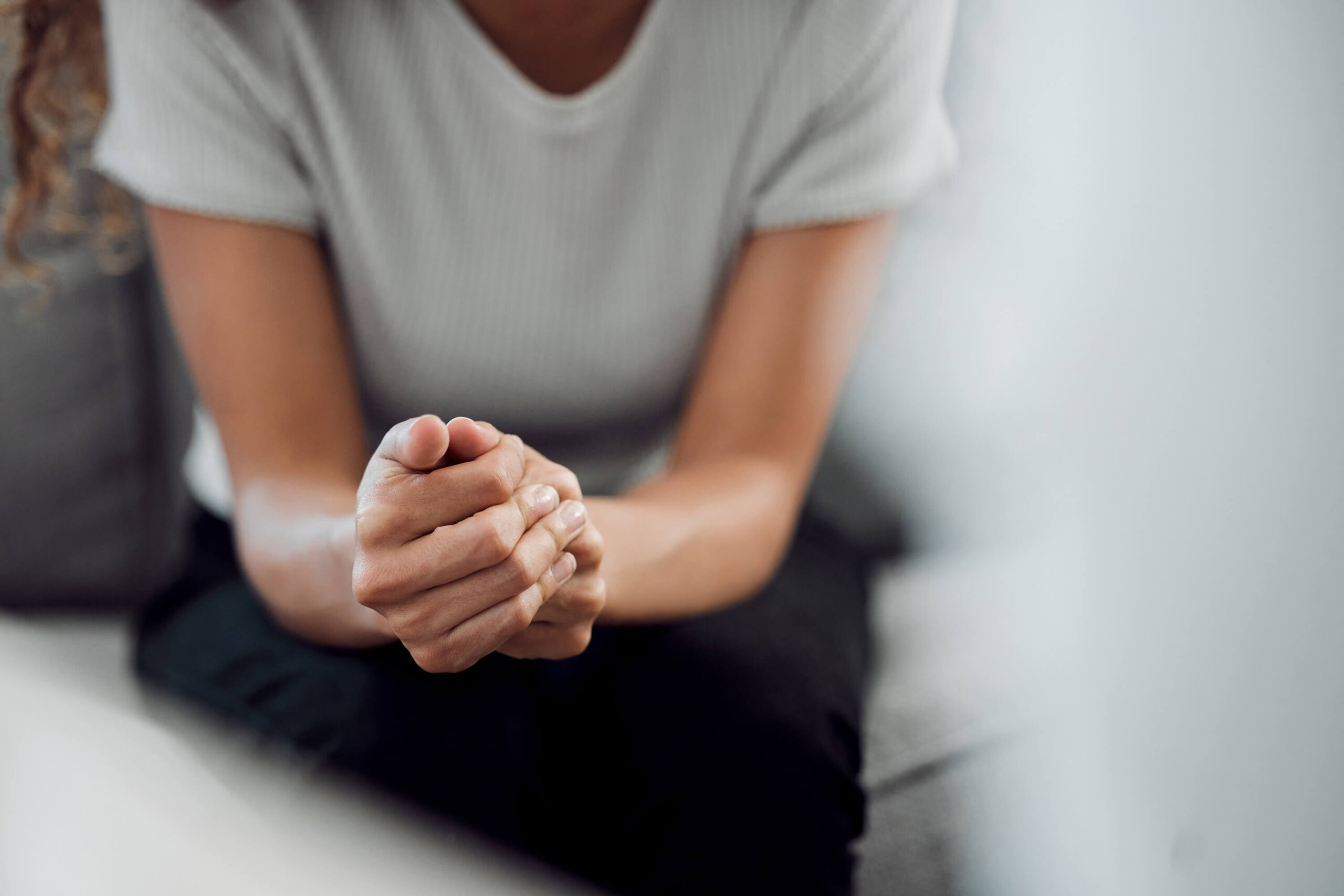 An individual experiencing a mental health crisis folds her hands