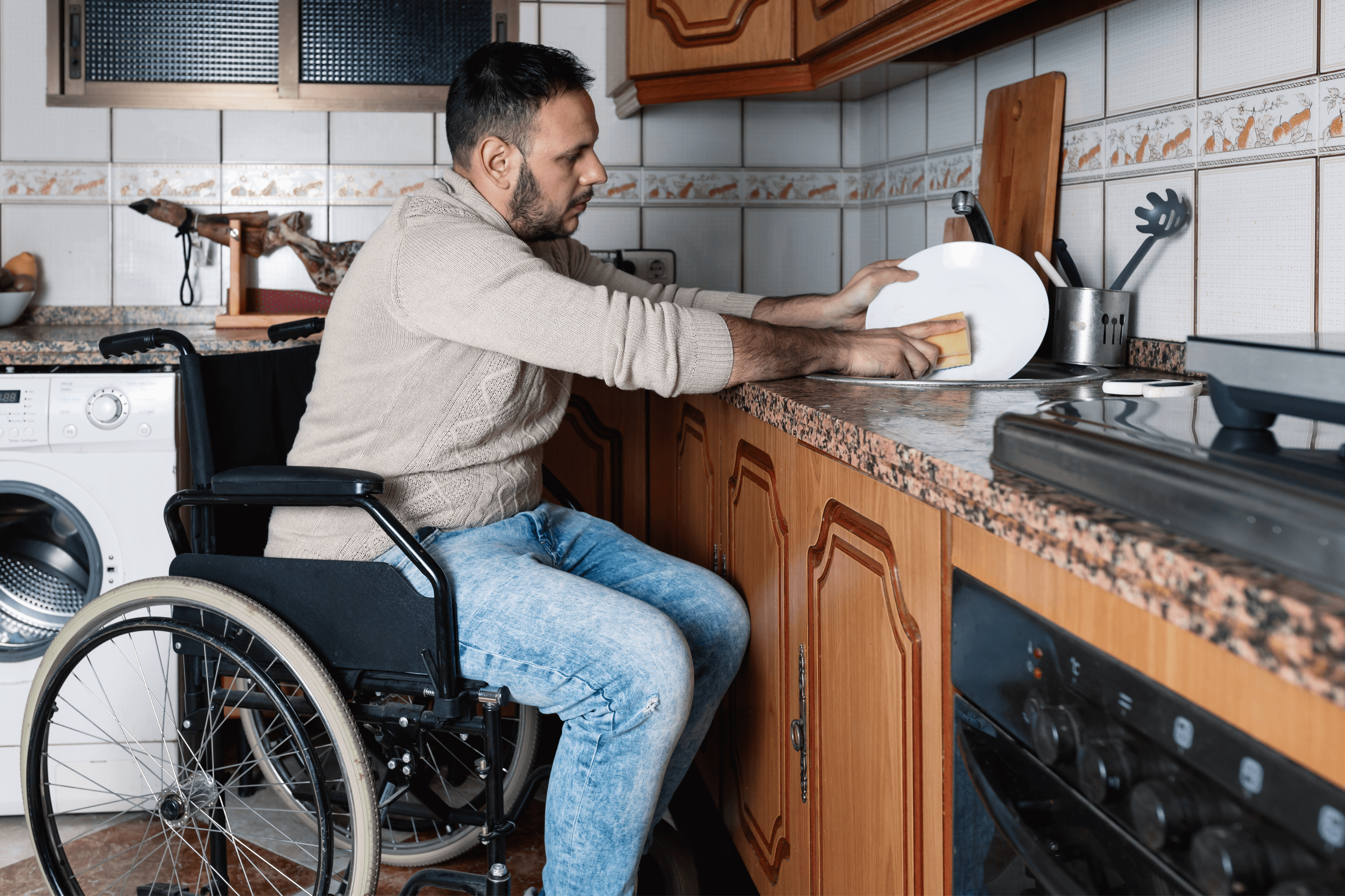 A man in a wheelchair washes dishes