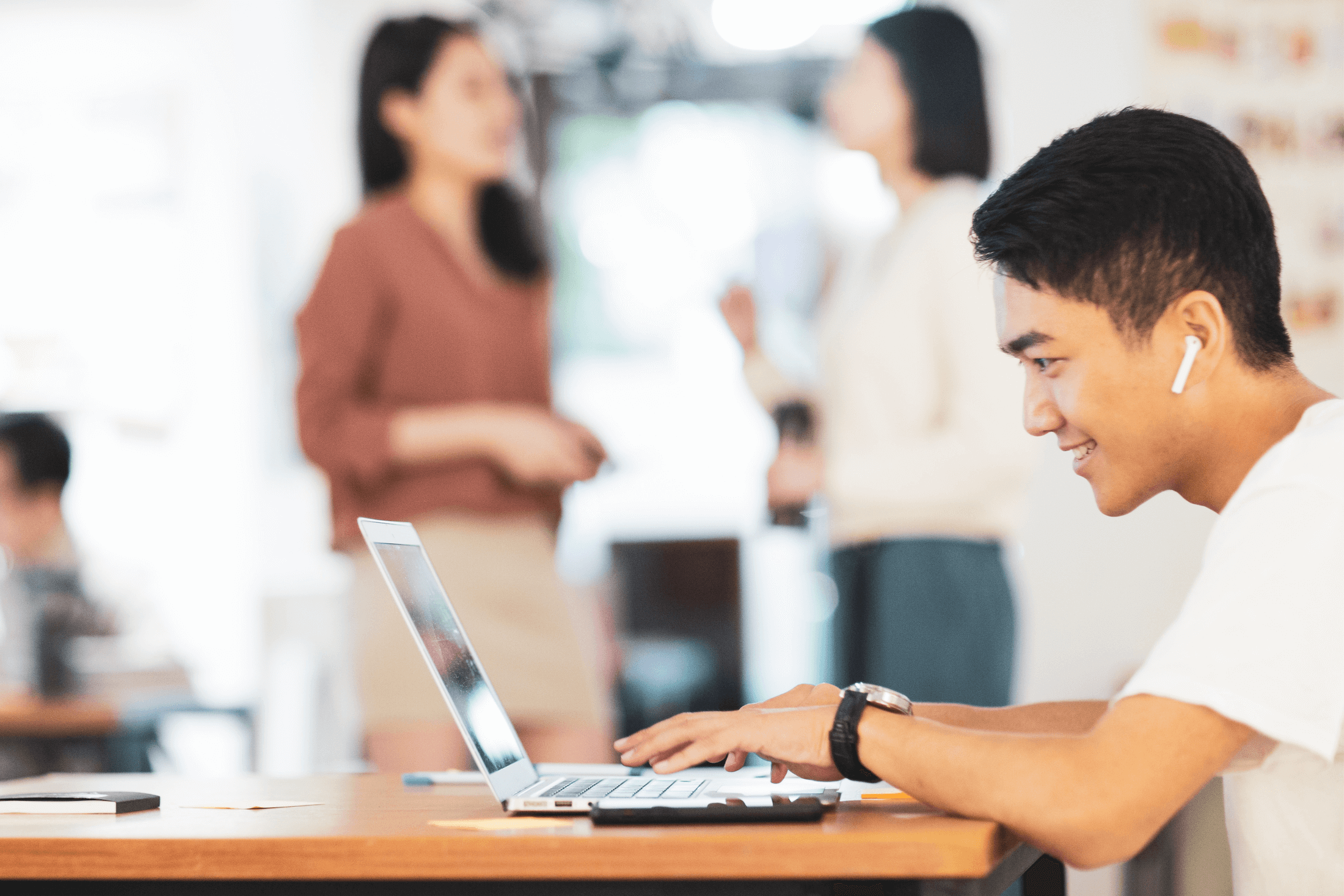 A young man uses his laptop to apply to a job in mental health at RHA