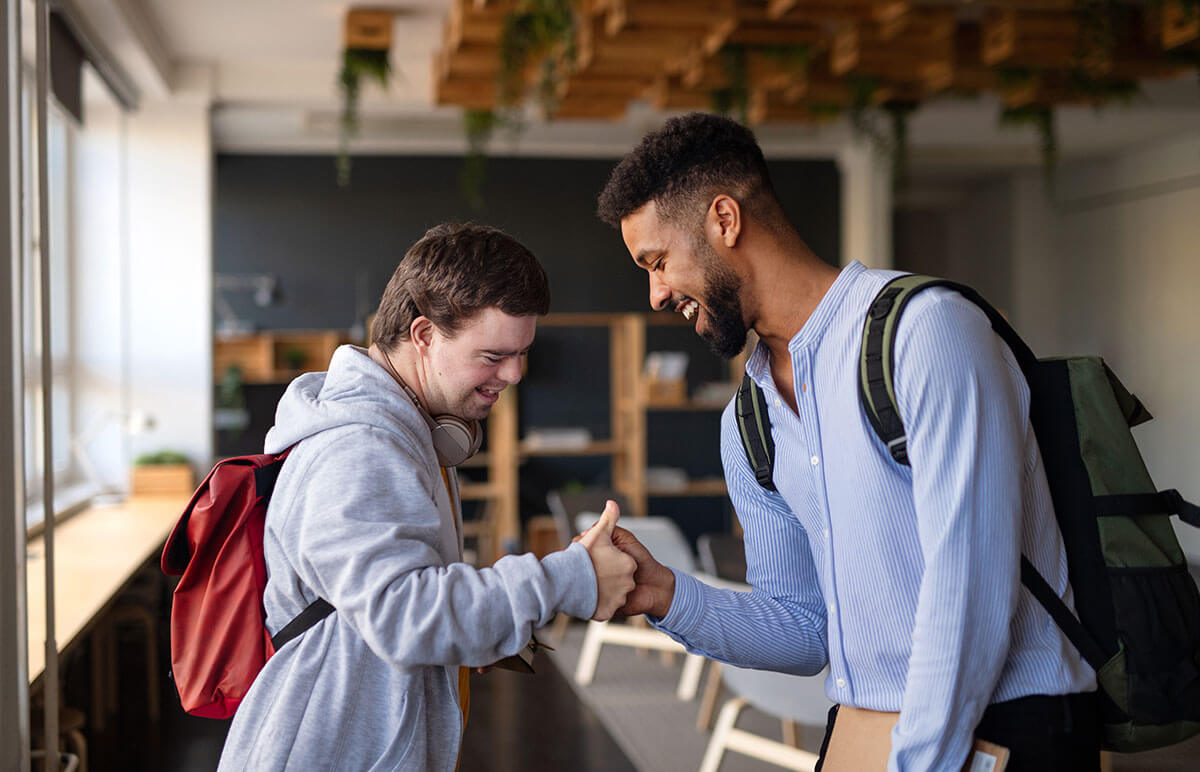 Friends shake hands in a classroom for comprehensive behavioral health services